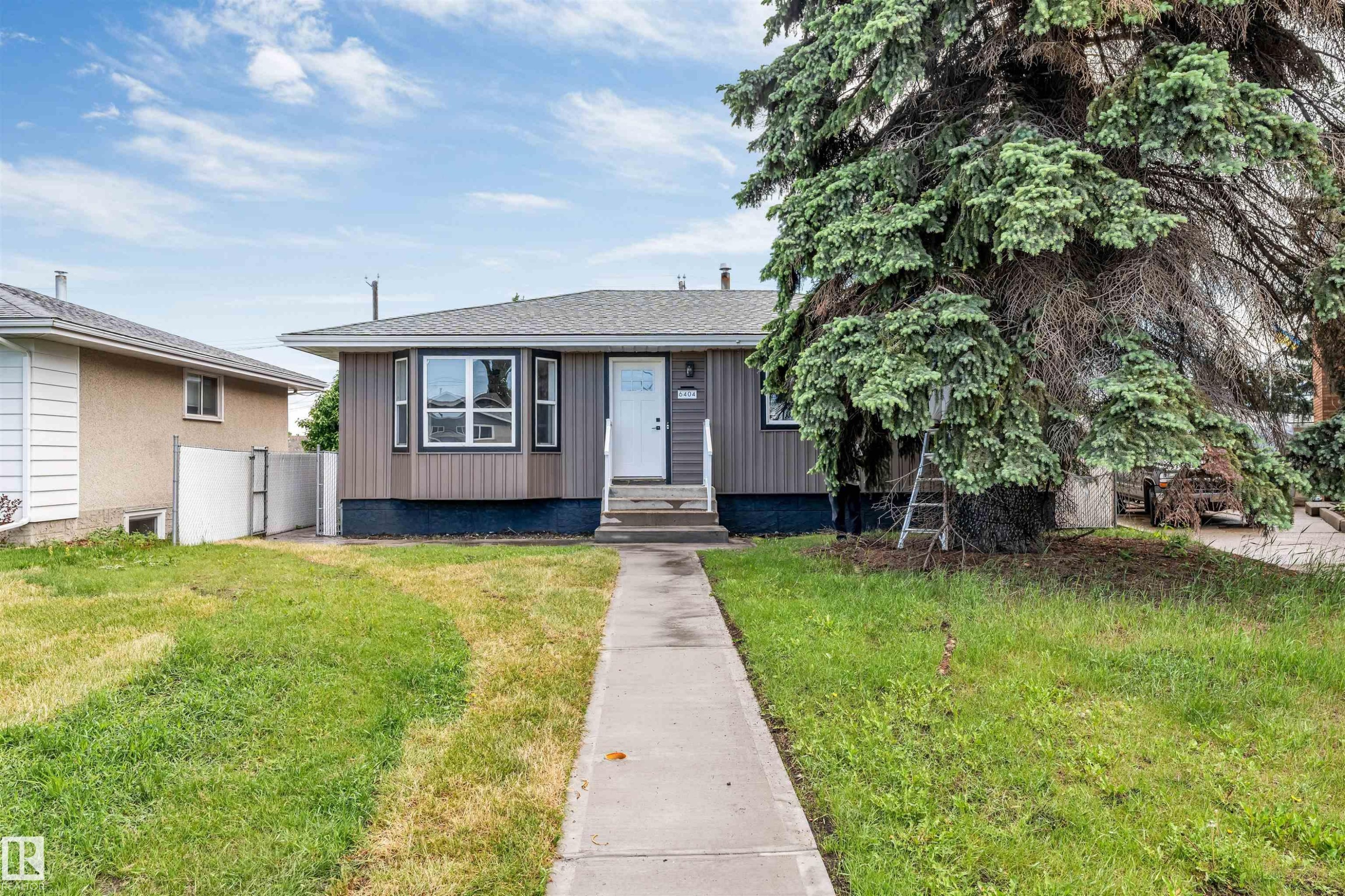 Ranch-style residence featuring vertical siding, a bay window, and a gabled roof - 6404 88 Avenue, Edmonton, AB