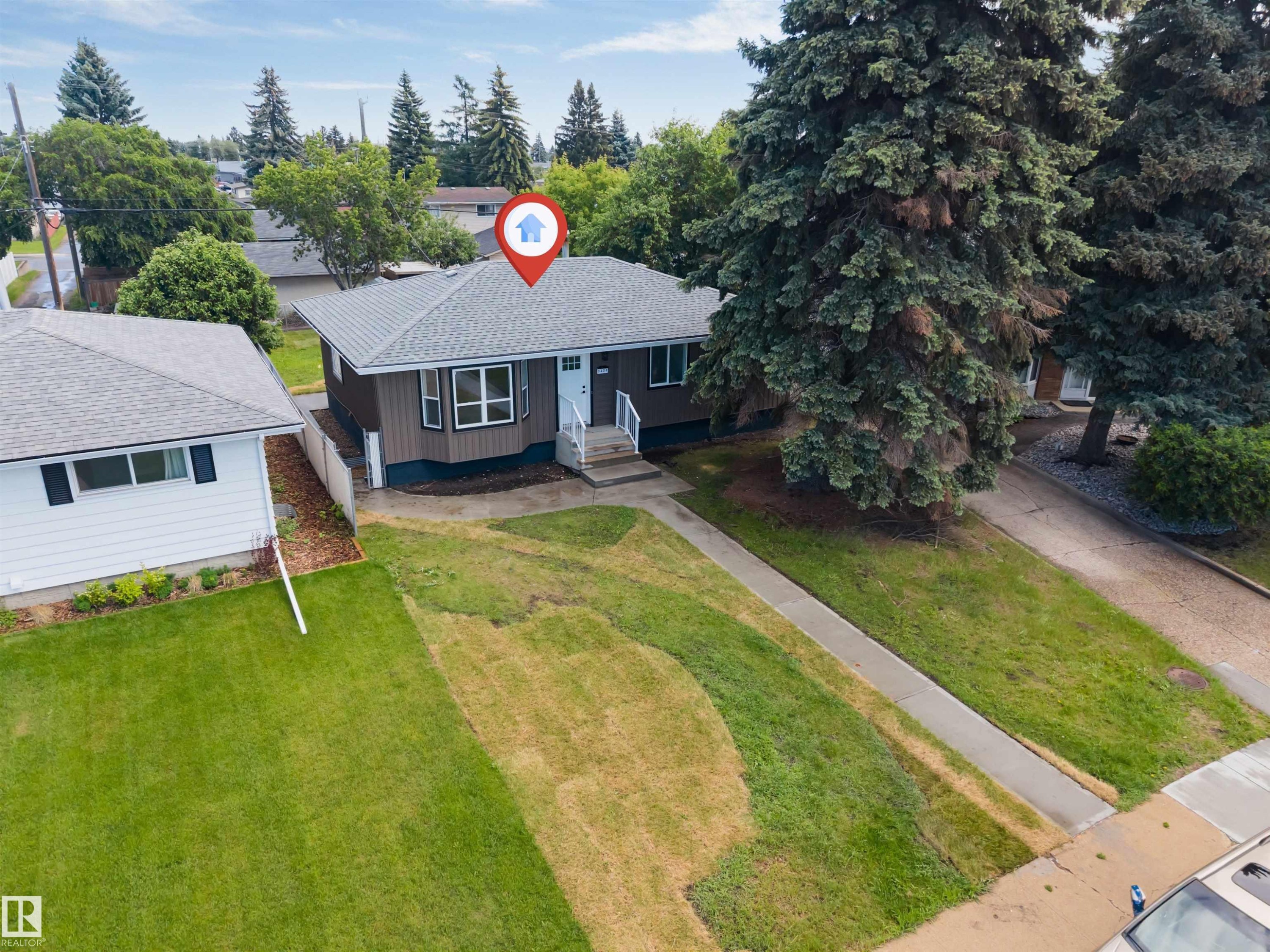 Single-story residence featuring brown siding with white trim and a light blue front door - 6404 88 Avenue, Edmonton, AB
