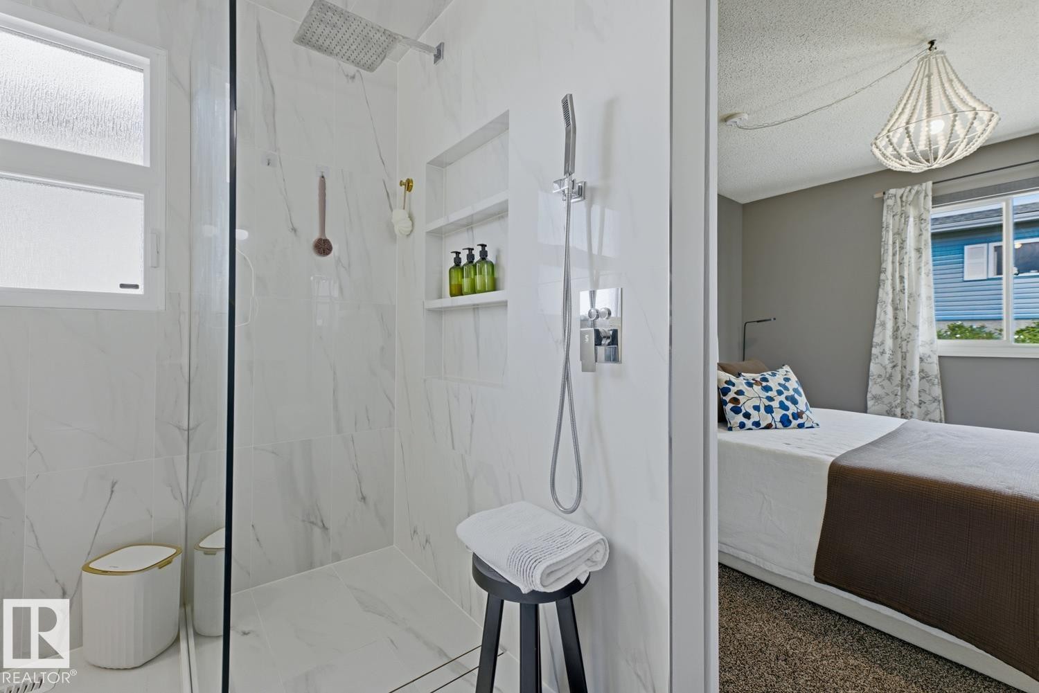 Walk-in shower with full-height marble-look tile surround, integrated shower niche, rainfall shower head, and an additional handheld shower fixture - 3504 102 Avenue, Edmonton, AB