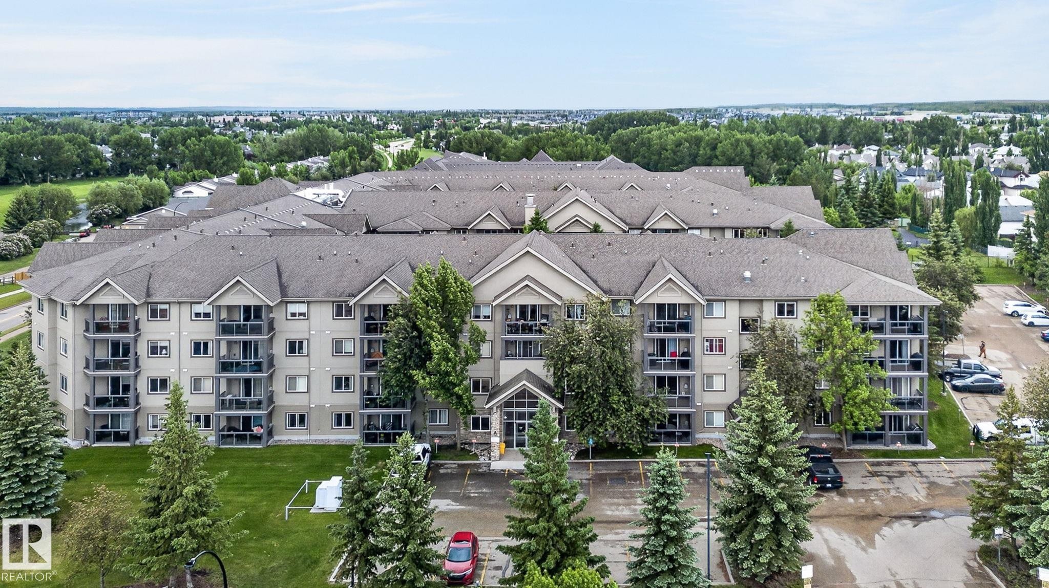 Multi-story residential building with private balconies and a neutral-toned exterior - 122 279 Suder Greens Drive, Edmonton, AB