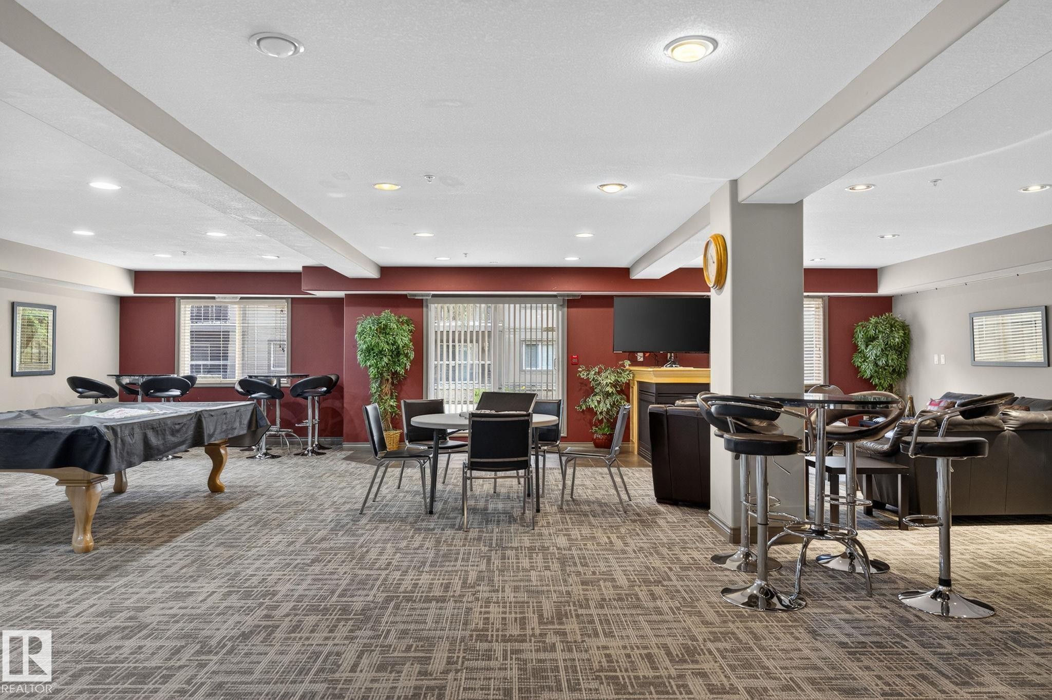 Spacious common area featuring patterned carpeting, recessed lighting, and accent walls - 122 279 Suder Greens Drive, Edmonton, AB