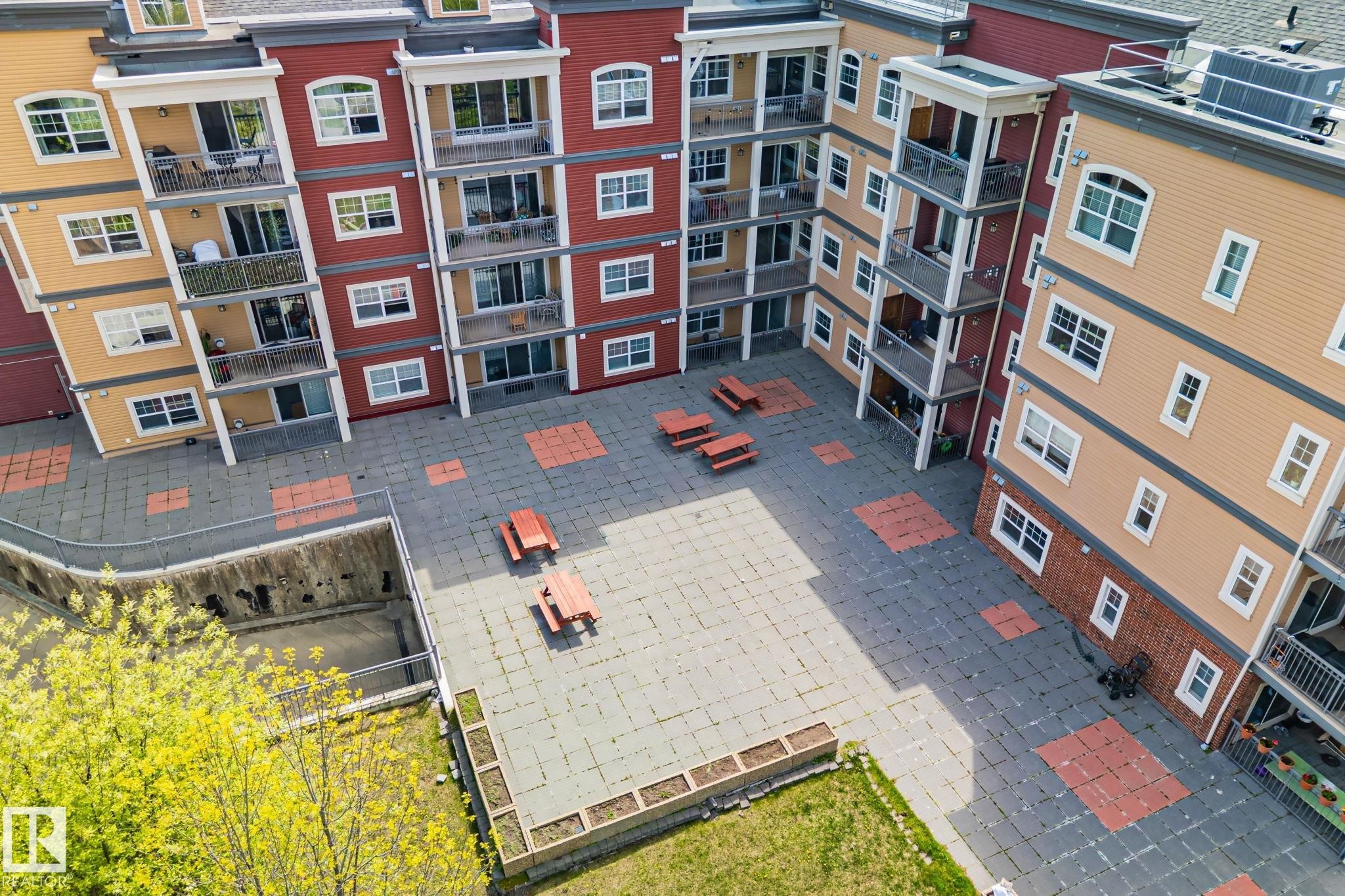 Central courtyard featuring paver stone surfacing with integrated red accent squares - 209 5280 Terwillegar Boulevard, Edmonton, AB - Outdoor