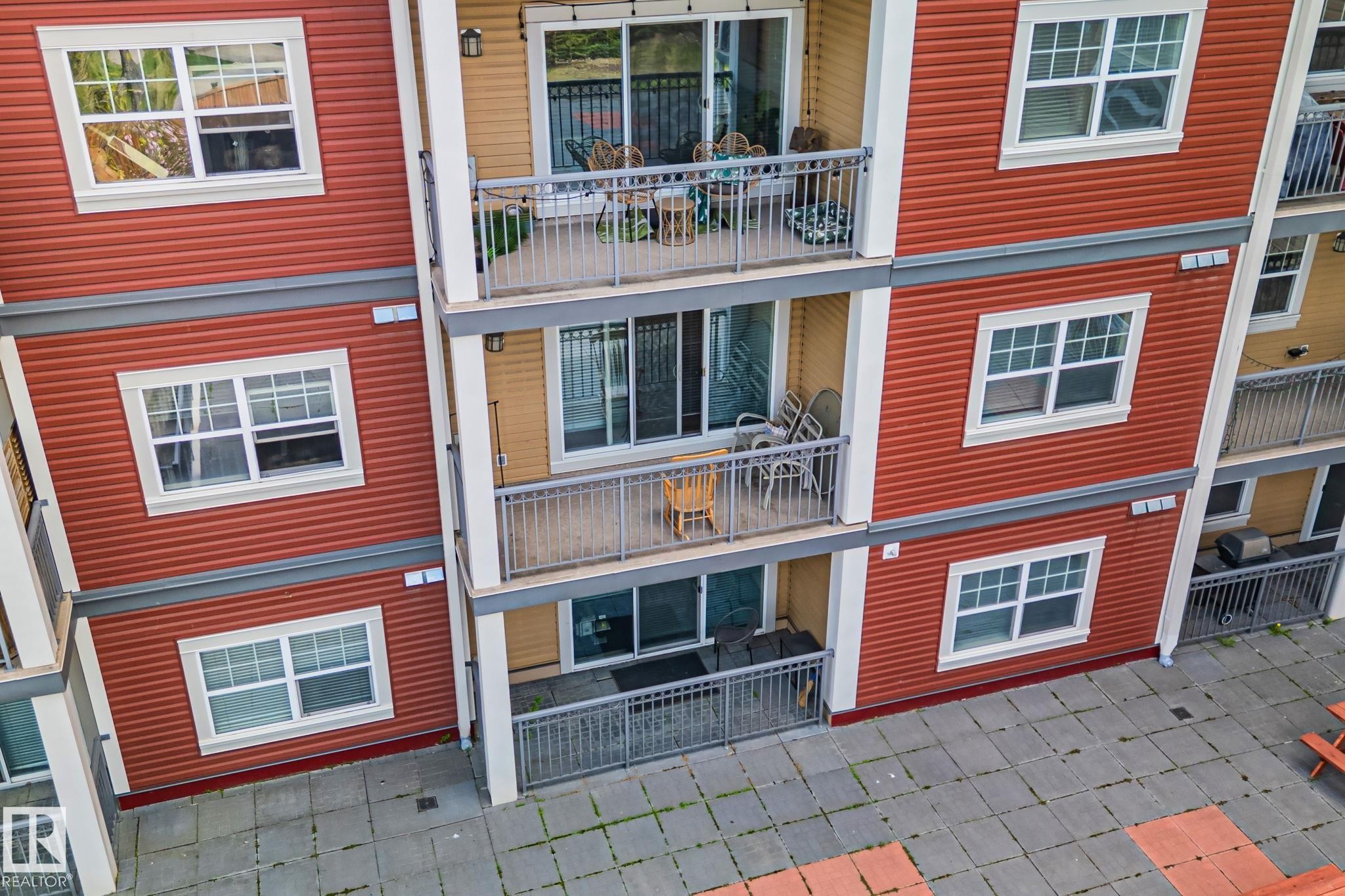 Multi-story building exterior with red horizontal siding and white trim - 209 5280 Terwillegar Boulevard, Edmonton, AB - Outdoor With Exterior