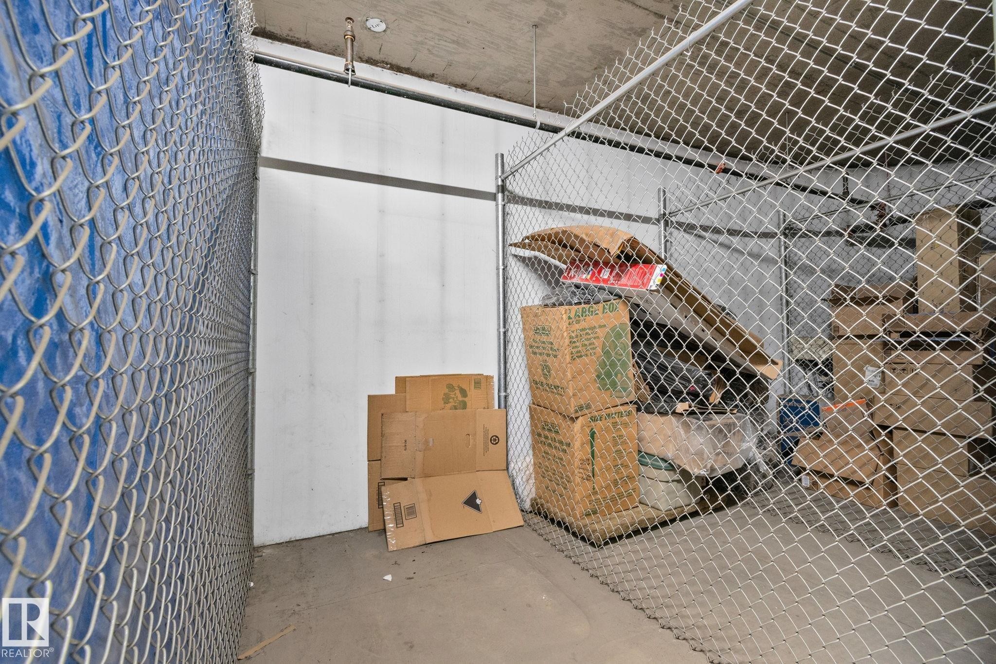 Dedicated storage unit featuring chain-link fencing, concrete flooring, and a concrete ceiling - 209 5280 Terwillegar Boulevard, Edmonton, AB - Indoor