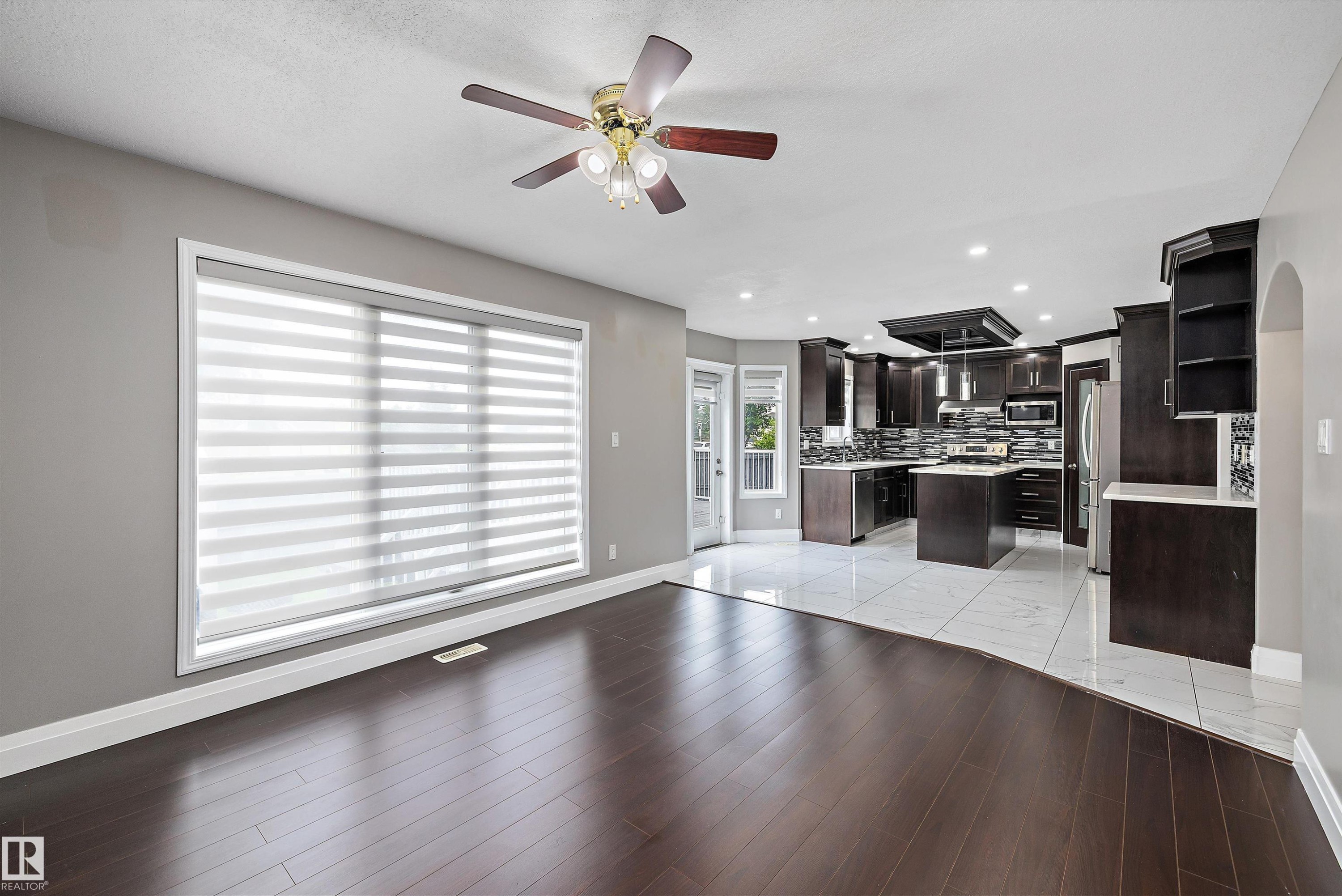 Expansive interior with dark wood-finish flooring and light gray walls - 4831 154 Avenue, Edmonton, AB