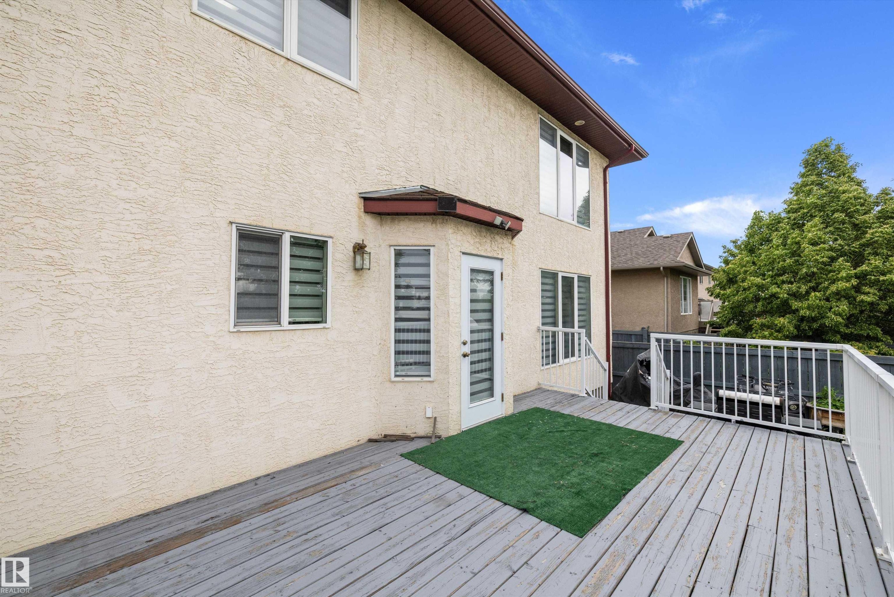 Expansive wooden deck featuring white railings and direct access to the interior - 4831 154 Avenue, Edmonton, AB