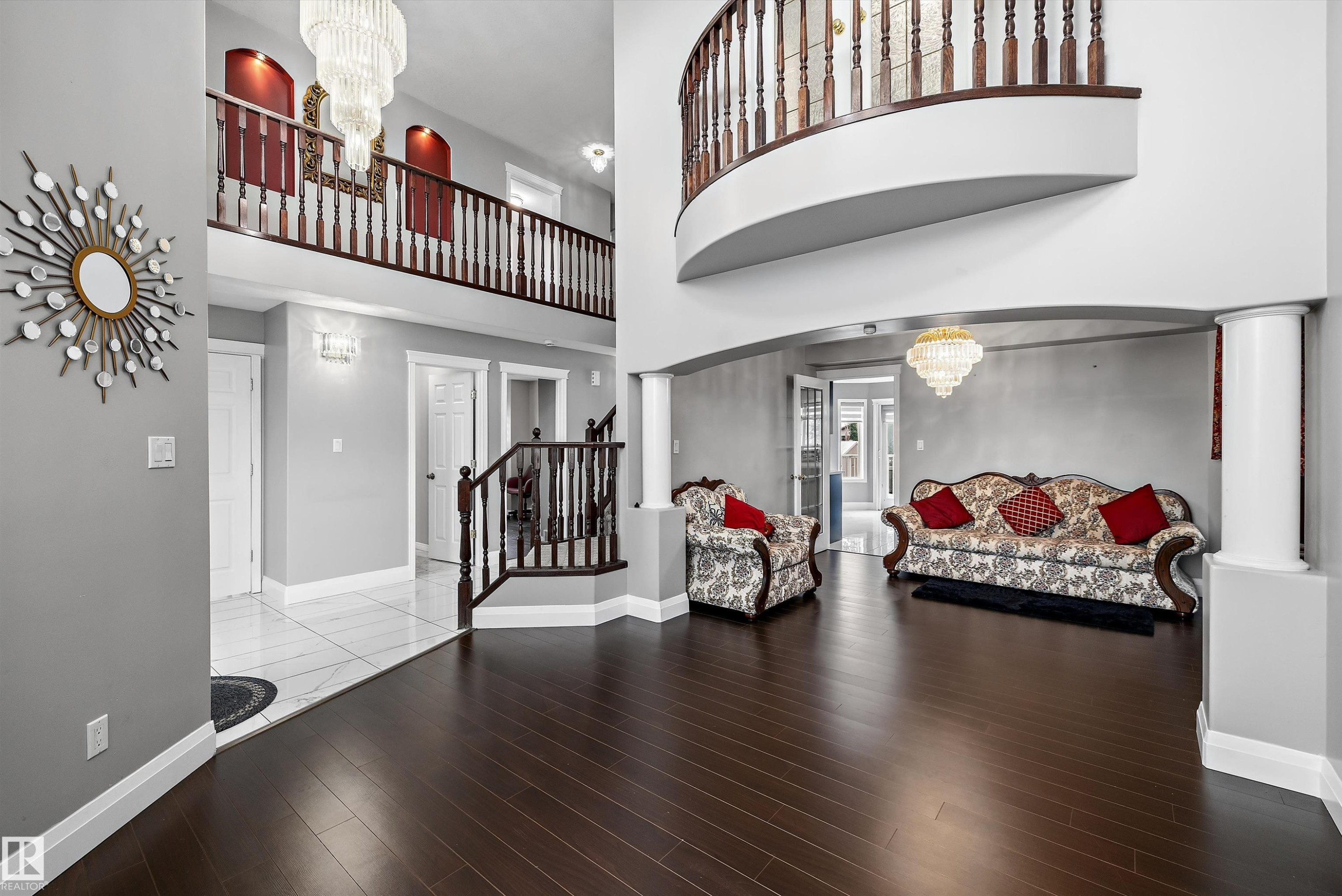 Two-story entry featuring dark wood-finish flooring, a grand staircase with wood balusters, and an upper-level overlook - 4831 154 Avenue, Edmonton, AB