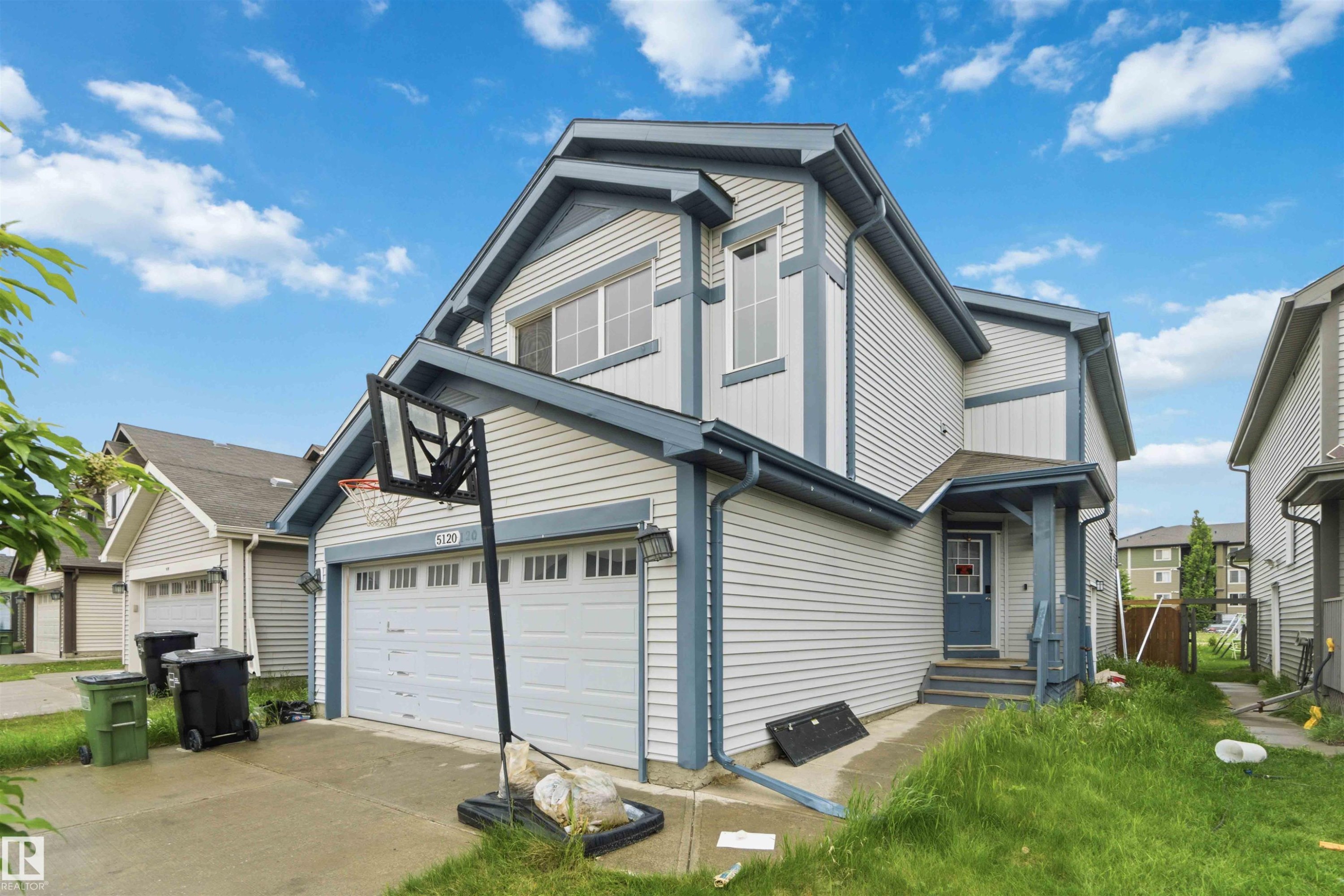 Two-story residence featuring light-toned siding with contrasting dark trim accents - 5120 19 Avenue, Edmonton, AB