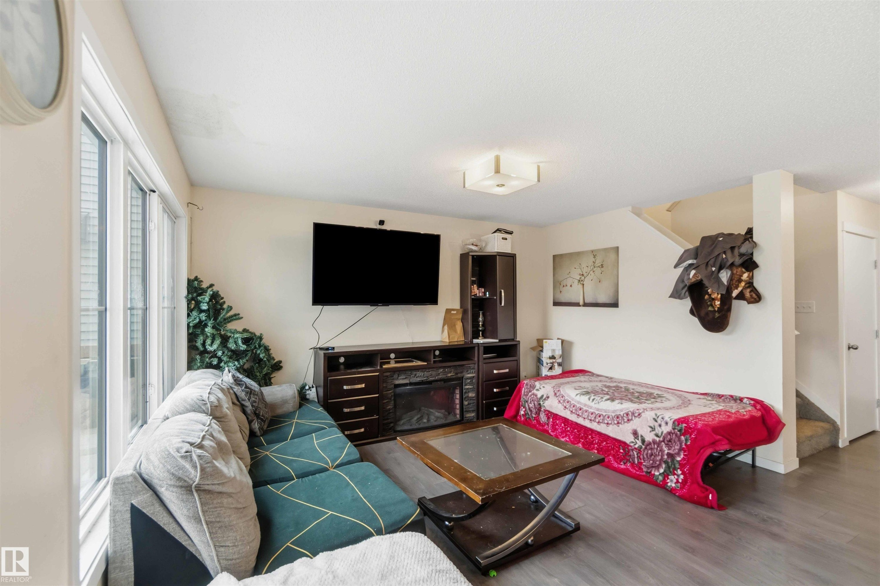 Living area featuring wood-finish flooring and light-toned walls - 5120 19 Avenue, Edmonton, AB