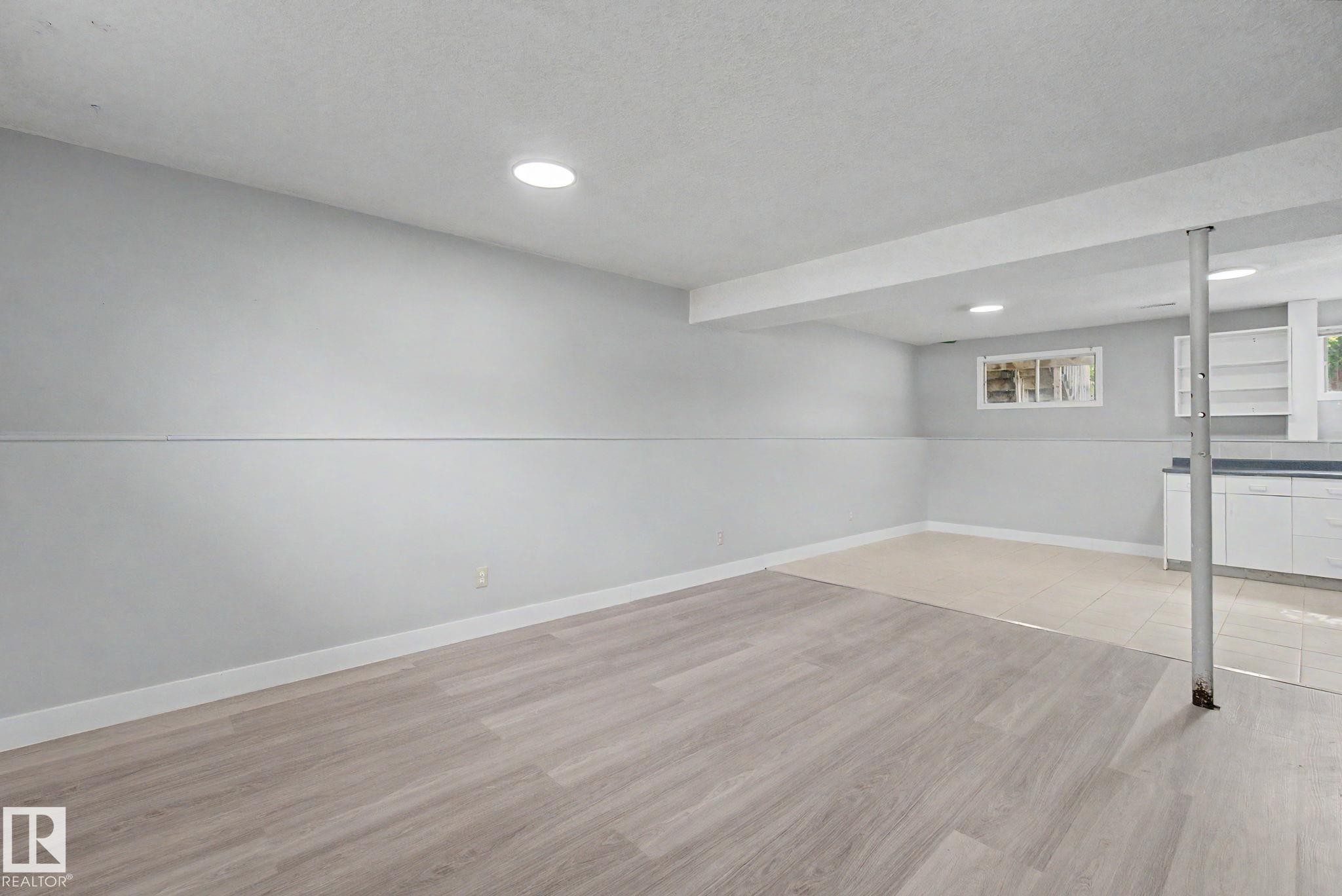 Finished lower level featuring recessed lighting, light wood-finish flooring, and white baseboards - 1511 75 Street, Edmonton, AB