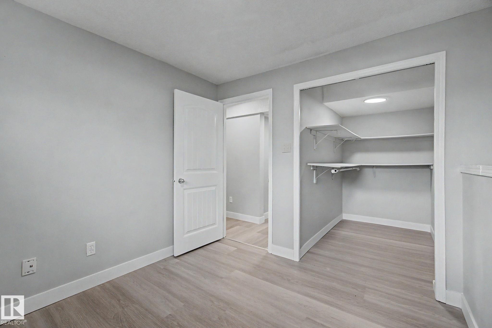 Bedroom featuring light gray walls, white trim, and wood-finish flooring - 1511 75 Street, Edmonton, AB