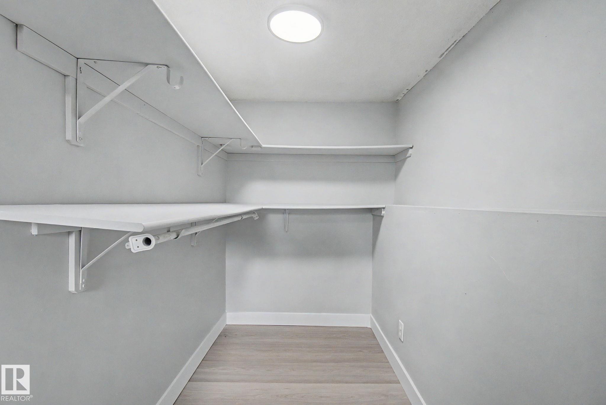 Dedicated storage space featuring built-in shelving, wood-finish flooring, recessed lighting, and crisp white trim - 1511 75 Street, Edmonton, AB