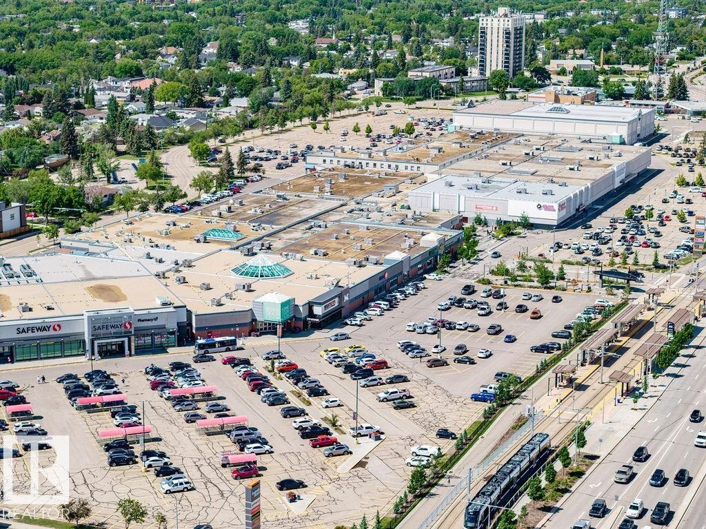 Expansive commercial complex featuring multiple retail establishments, extensive surface parking, and direct access to a light rail transit line - 8318 80 Avenue Nw, Edmonton, AB - Outdoor With View