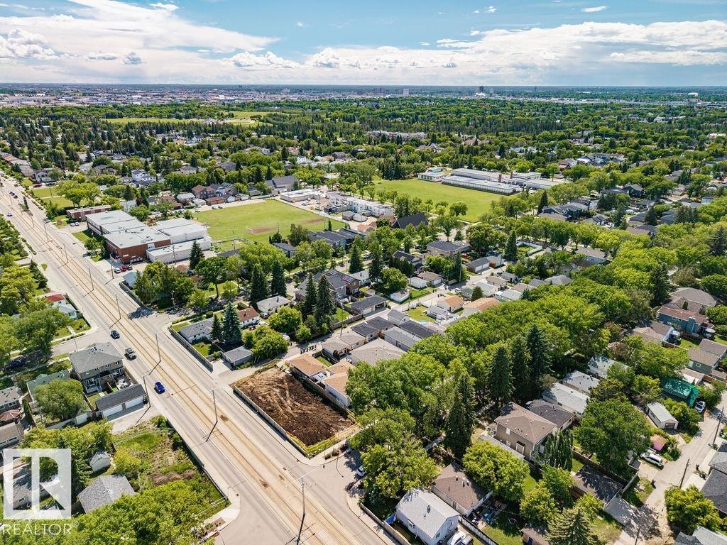 Aerial perspective showcasing a residential area with mature tree canopies, paved roadways, and a large green space - 8318 80 Avenue Nw, Edmonton, AB - Outdoor With View