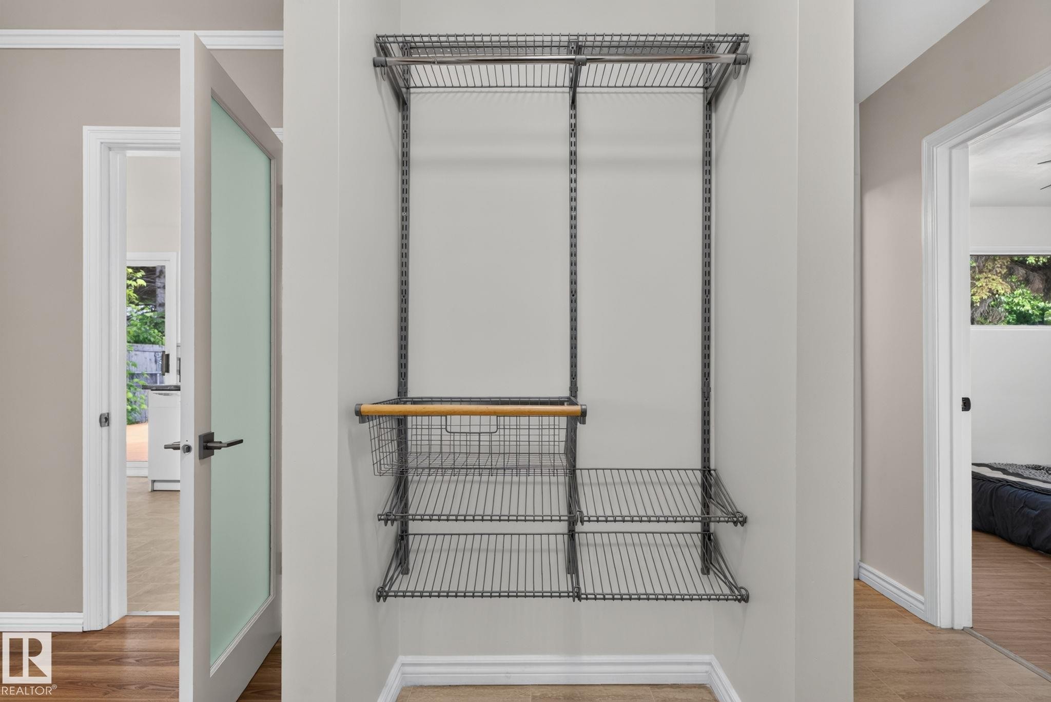 Custom wire shelving system featuring multiple shelves, two hanging rods, and an integrated basket drawer with a wood-finish handle - 12952 114 Street Nw, Edmonton, AB