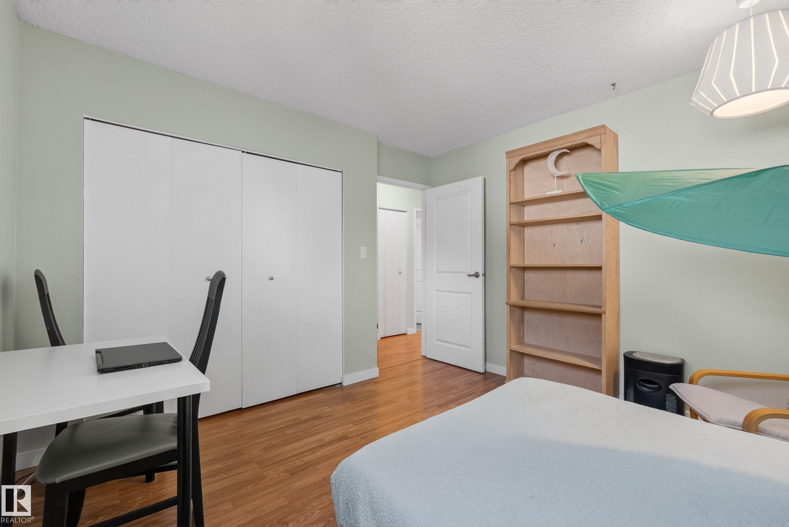 Warm wood-finish flooring complements light-toned walls - 10935 152 Street, Edmonton, AB