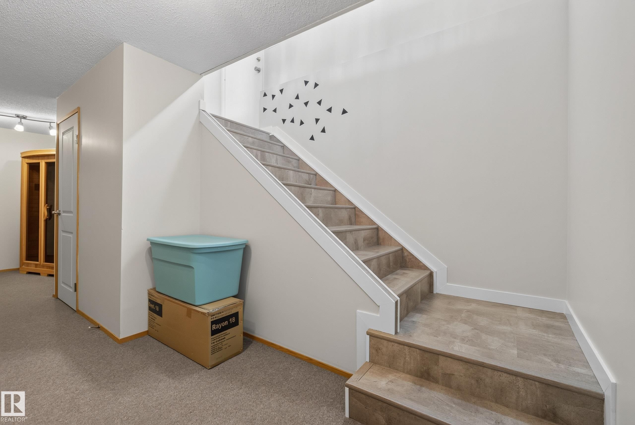 Staircase featuring tile-finish risers and treads, white trim, and a neutral wall finish - 10935 152 Street, Edmonton, AB