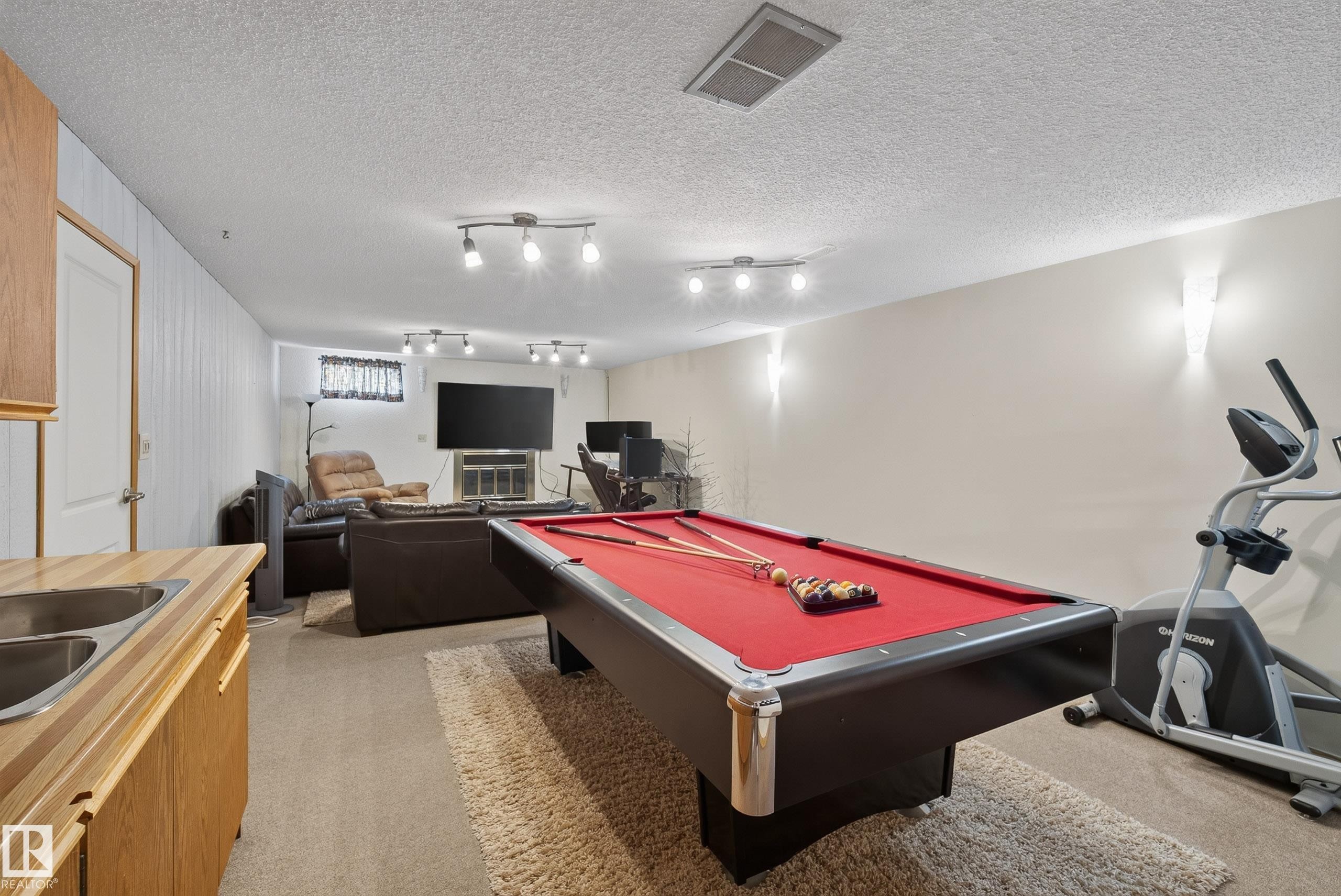 Spacious recreational area featuring a red felt billiards table - 10935 152 Street, Edmonton, AB