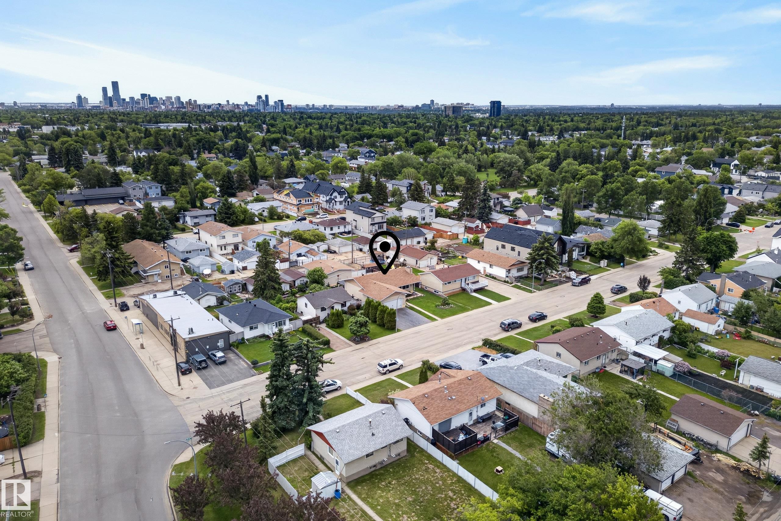 Aerial perspective showcasing a residential street with mature trees and a distant city skyline - 10935 152 Street, Edmonton, AB
