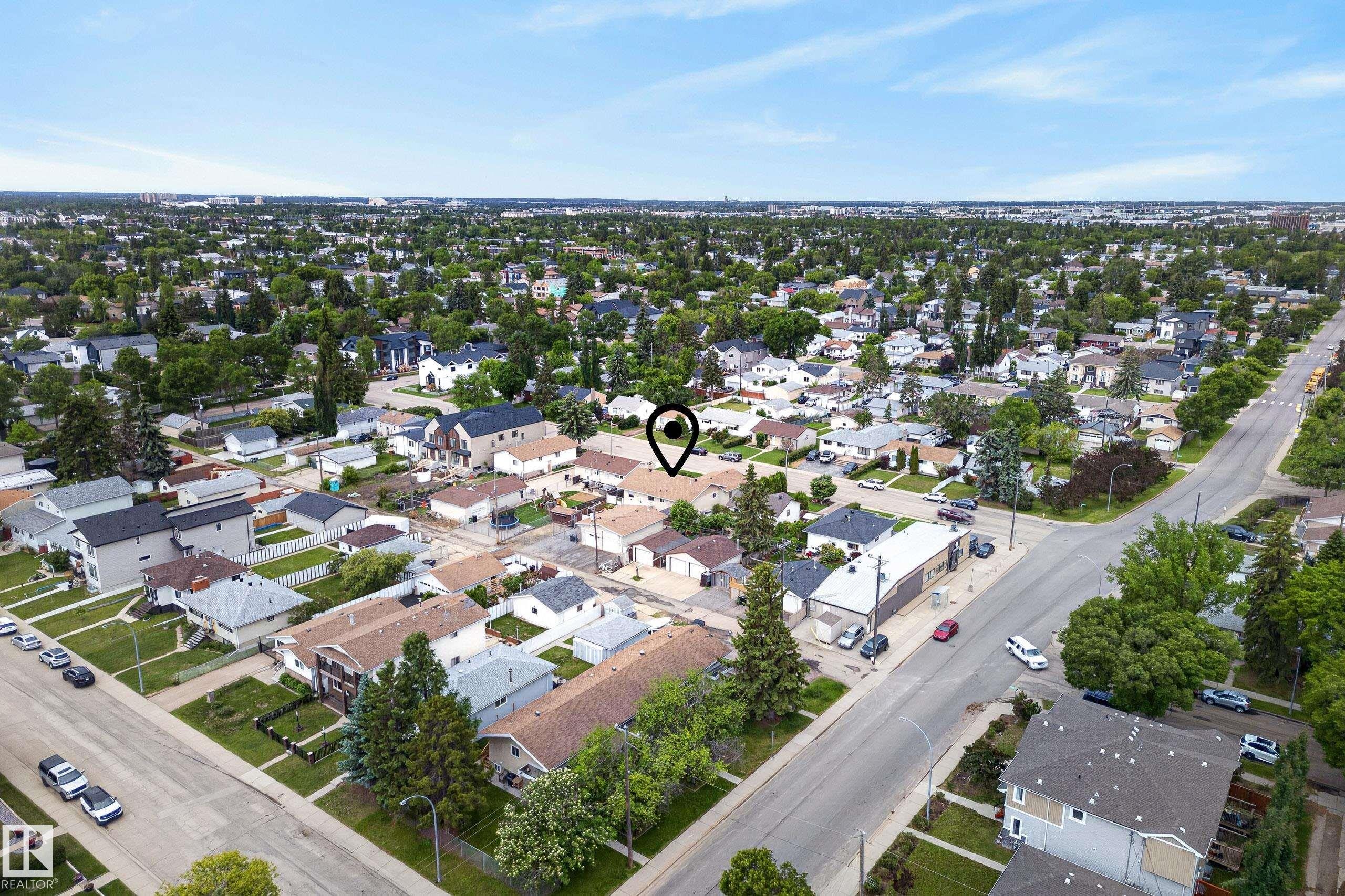 Residential neighborhood featuring a mix of single-family homes and multi-story dwellings, established street grid, abundant mature trees, and clear sky conditions - 10935 152 Street, Edmonton, AB
