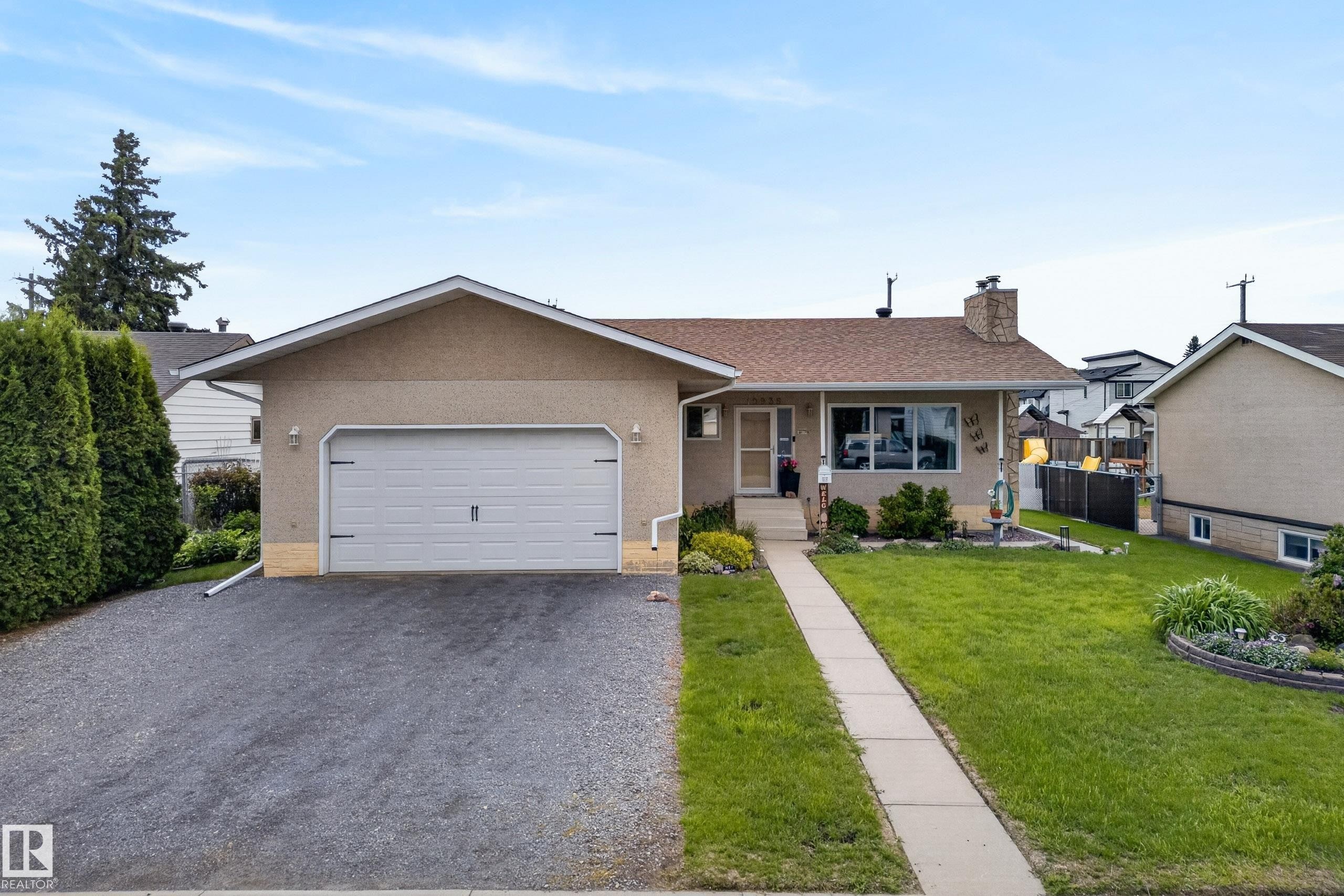 Ranch-style residence featuring a prominent attached garage with a white overhead door - 10935 152 Street, Edmonton, AB