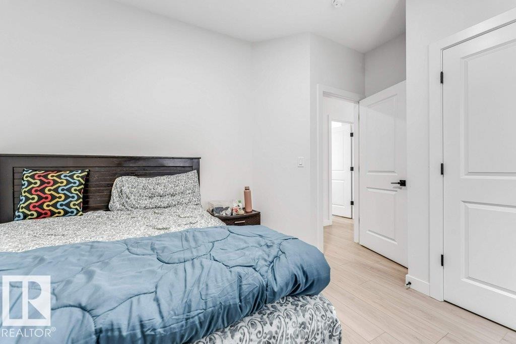 Light wood-finish flooring complements clean white walls - 423 28 Street, Edmonton, AB