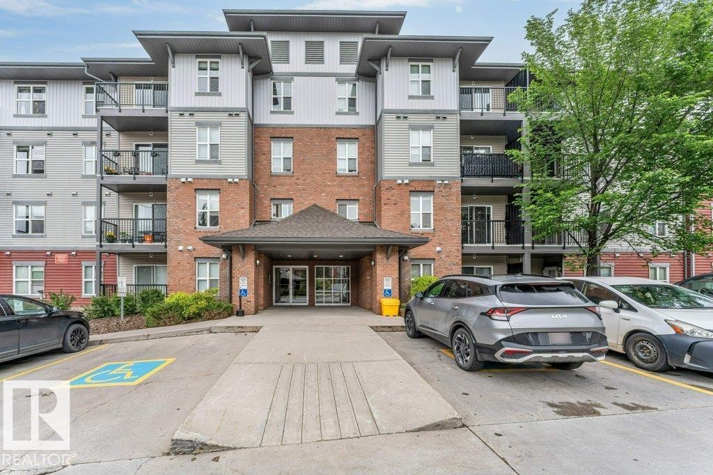 Multi-story building facade featuring brick and siding accents - 401 667 Watt Boulevard, Edmonton, AB
