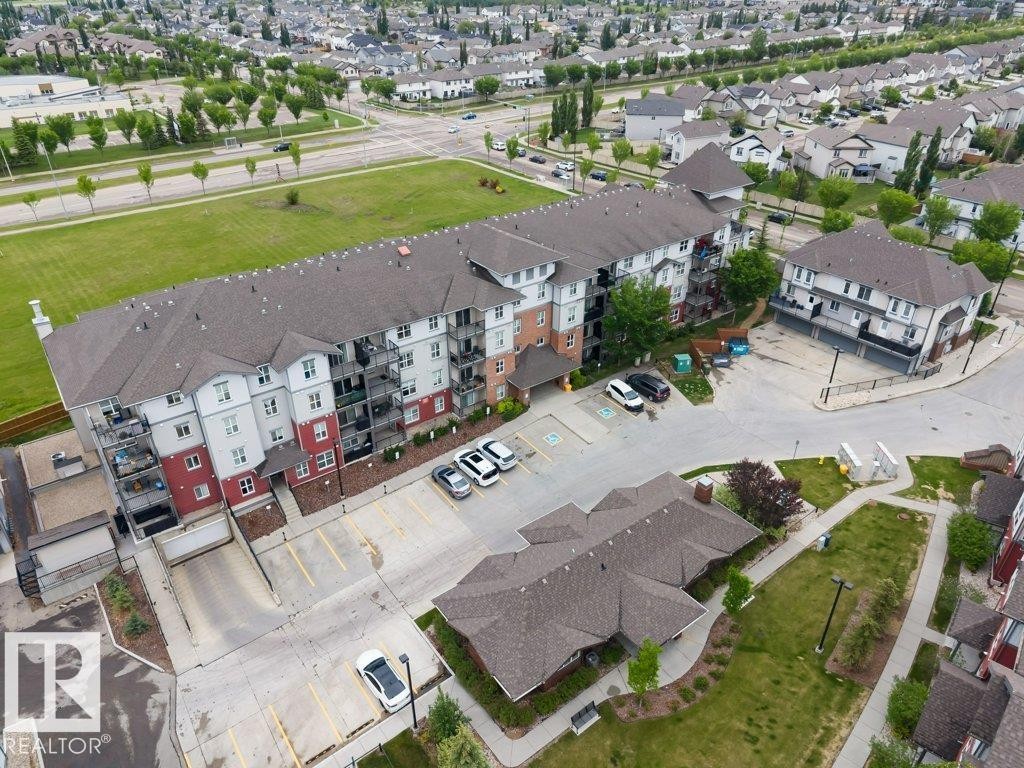 Multi-story residential building featuring a multi-tone facade with red and white siding - 401 667 Watt Boulevard, Edmonton, AB