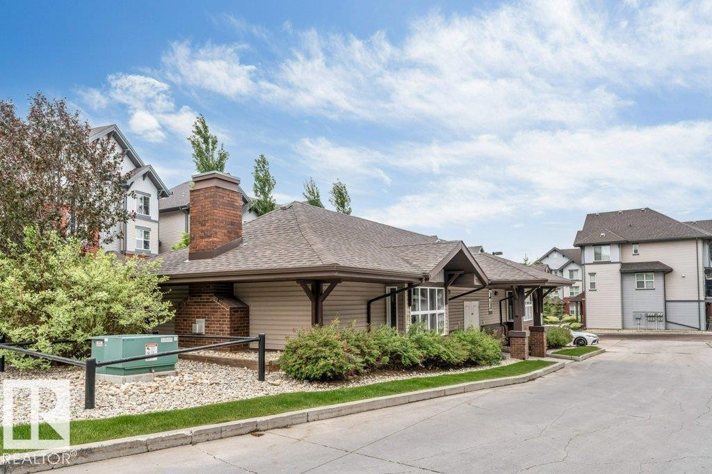 Community clubhouse with brick chimney detail and covered entry - 401 667 Watt Boulevard, Edmonton, AB