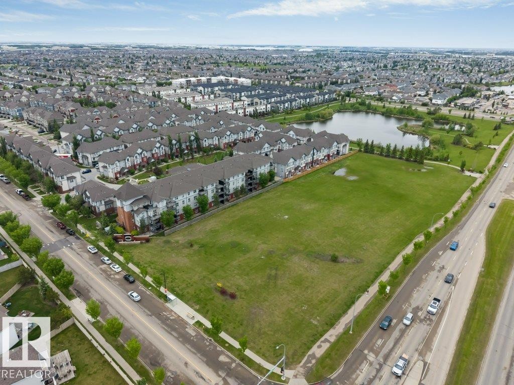 Expansive green space bordered by a multi-lane roadway and residential development - 401 667 Watt Boulevard, Edmonton, AB