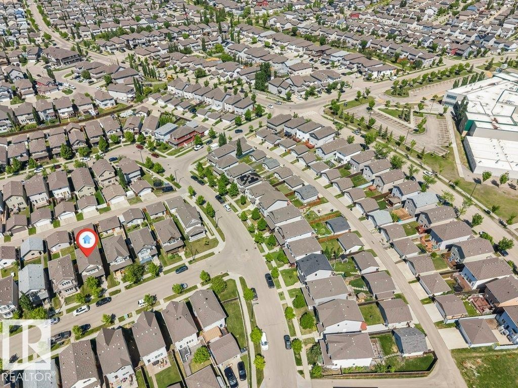 Aerial perspective showcasing a residential neighborhood with numerous single-family homes, tree-lined streets, and paved roadways - 3511 15A Street, Edmonton, AB