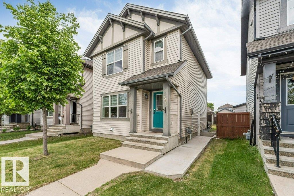 Two-story residential exterior featuring light-colored siding with dark trim accents - 3511 15A Street, Edmonton, AB
