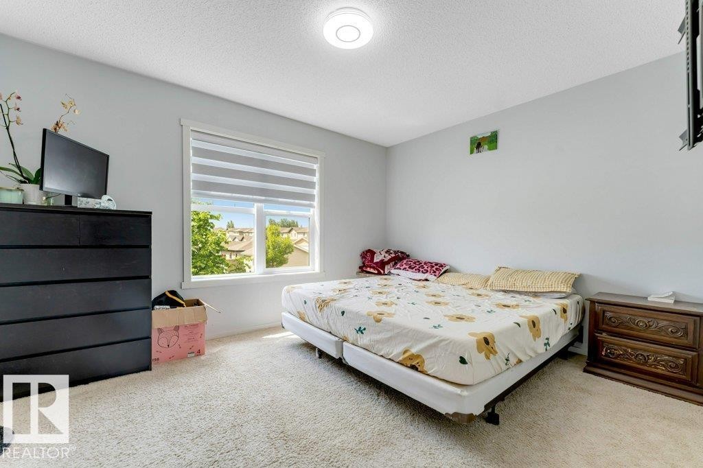 Bright room featuring light gray walls, a window with horizontal blinds, and off-white carpeting - 3511 15A Street, Edmonton, AB