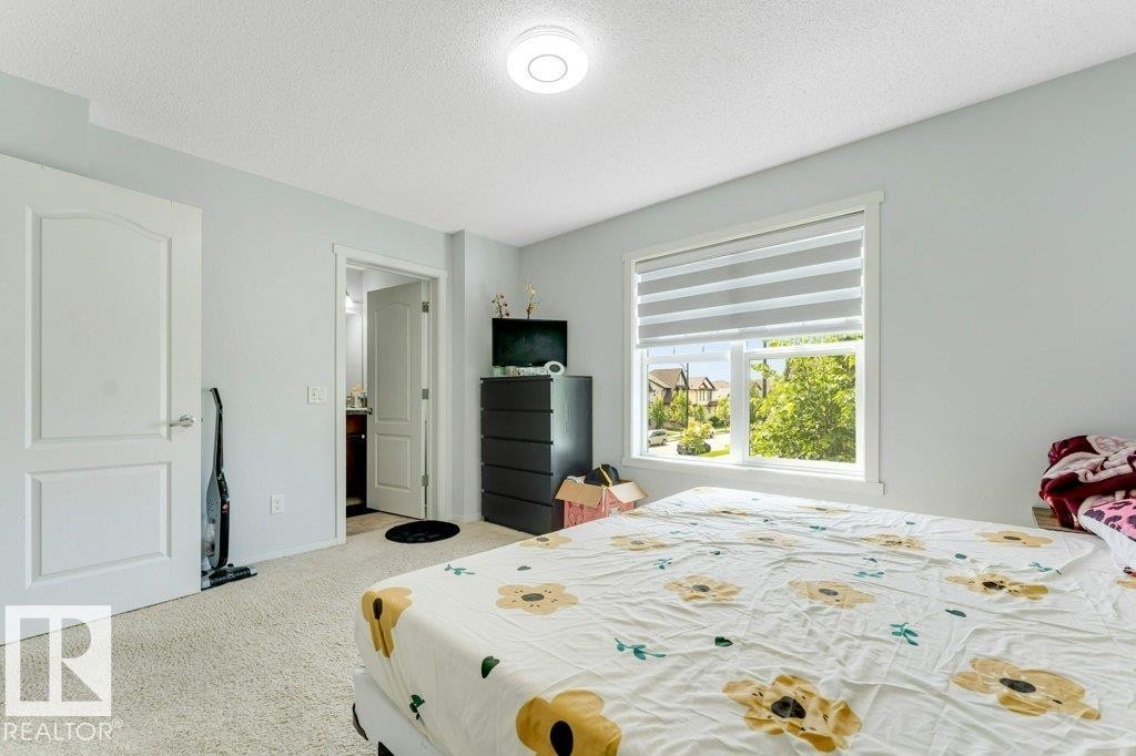 Carpeted room with a large window featuring horizontal blinds - 3511 15A Street, Edmonton, AB