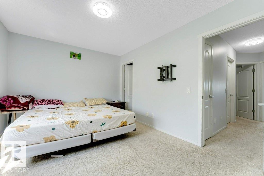 Carpeted room featuring light gray wall paint, a ceiling-mounted light fixture, and white trim - 3511 15A Street, Edmonton, AB