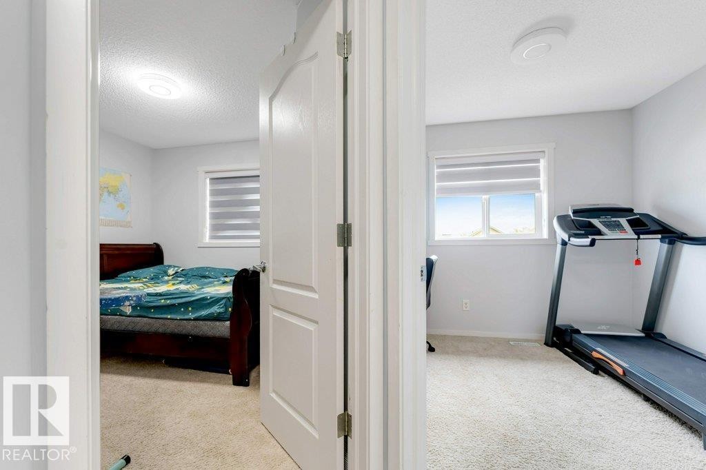 Two separate rooms each featuring carpet flooring, white walls, a window with horizontal blinds, and a flush mount ceiling light - 3511 15A Street, Edmonton, AB