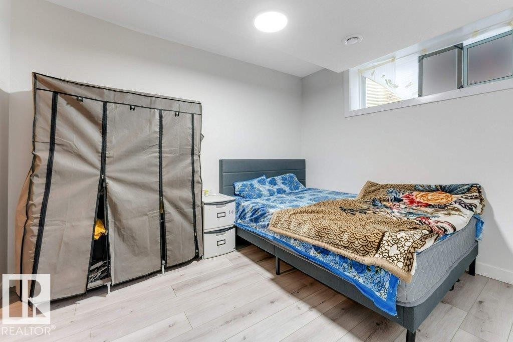 Light wood-finish flooring with crisp white walls, a recessed ceiling light, and a horizontal window - 3511 15A Street, Edmonton, AB