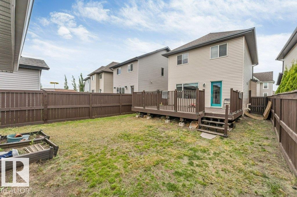 Rear exterior featuring a spacious wooden deck with railings and steps - 3511 15A Street, Edmonton, AB