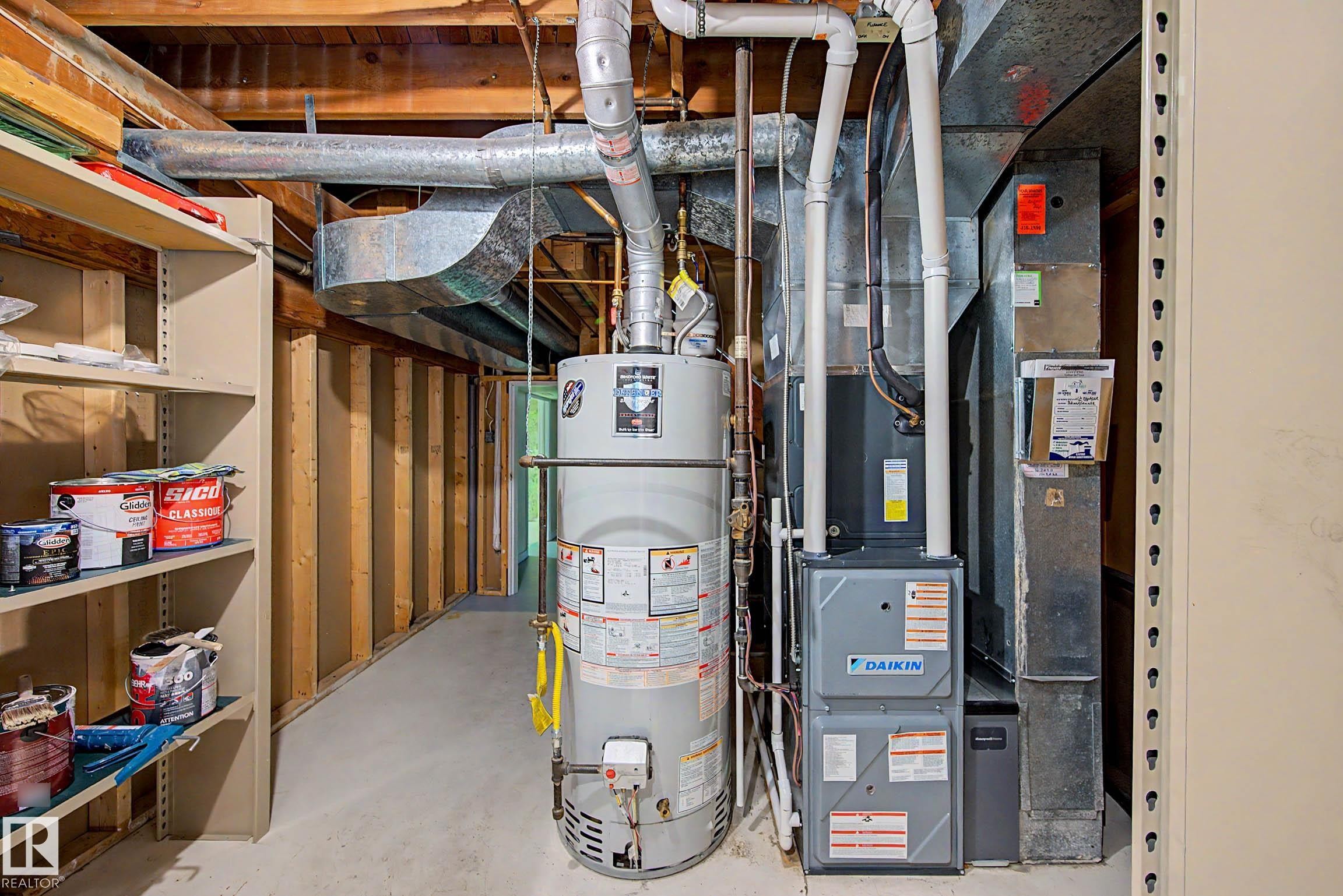 Utility area featuring a water heater, furnace, and exposed overhead ductwork - 3718 103B Street Nw, Edmonton, AB - Indoor Photo Showing Basement