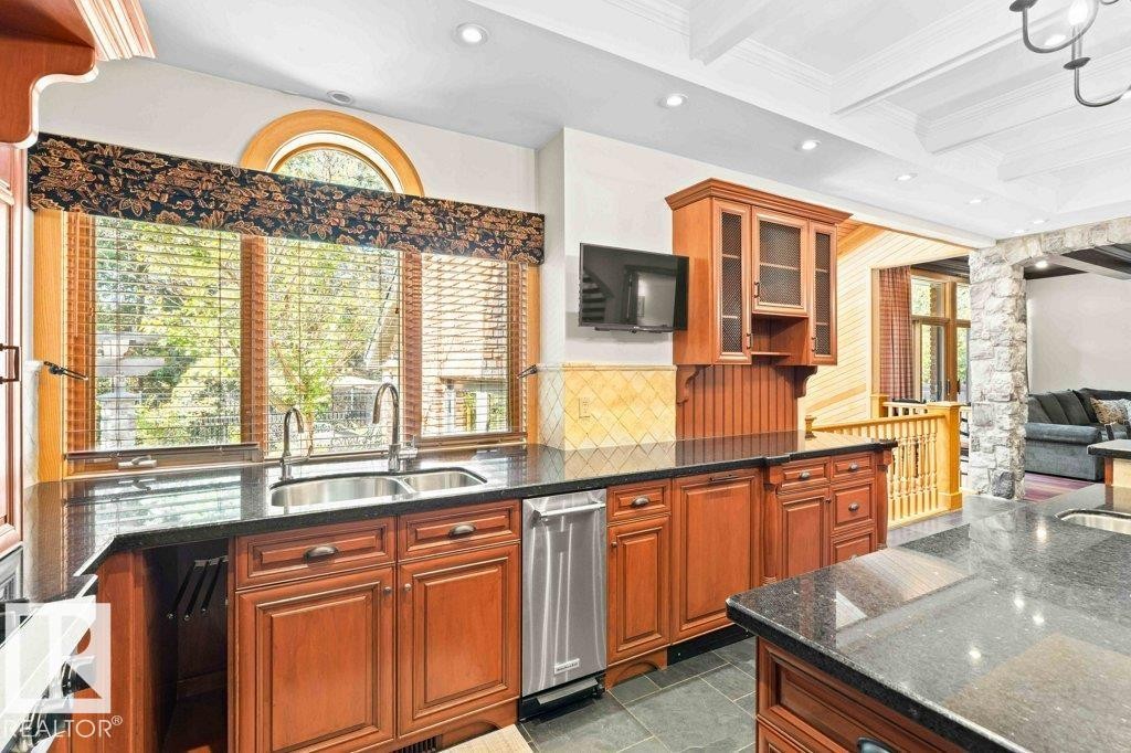 Kitchen with granite countertops, custom tile backsplash, Miele, Subzero and KitchenAid appliances featuring trash compactor, dual wall ovens plus garburator. - 738 Wheeler Road, Edmonton, AB
