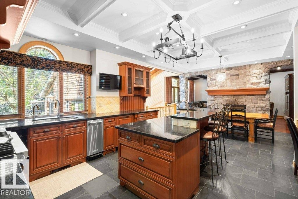 Kitchen with granite countertops, custom tile backsplash, Miele, Subzero and KitchenAid appliances featuring trash compactor, dual wall ovens plus garburator. - 738 Wheeler Road, Edmonton, AB