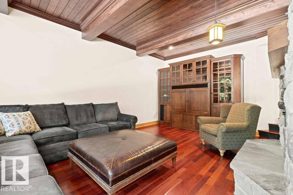 Family room featuring two sided wood burning fireplace, Brazilian Cherry hardwood flooring with custom millwork and wood ceiling. - 738 Wheeler Road, Edmonton, AB