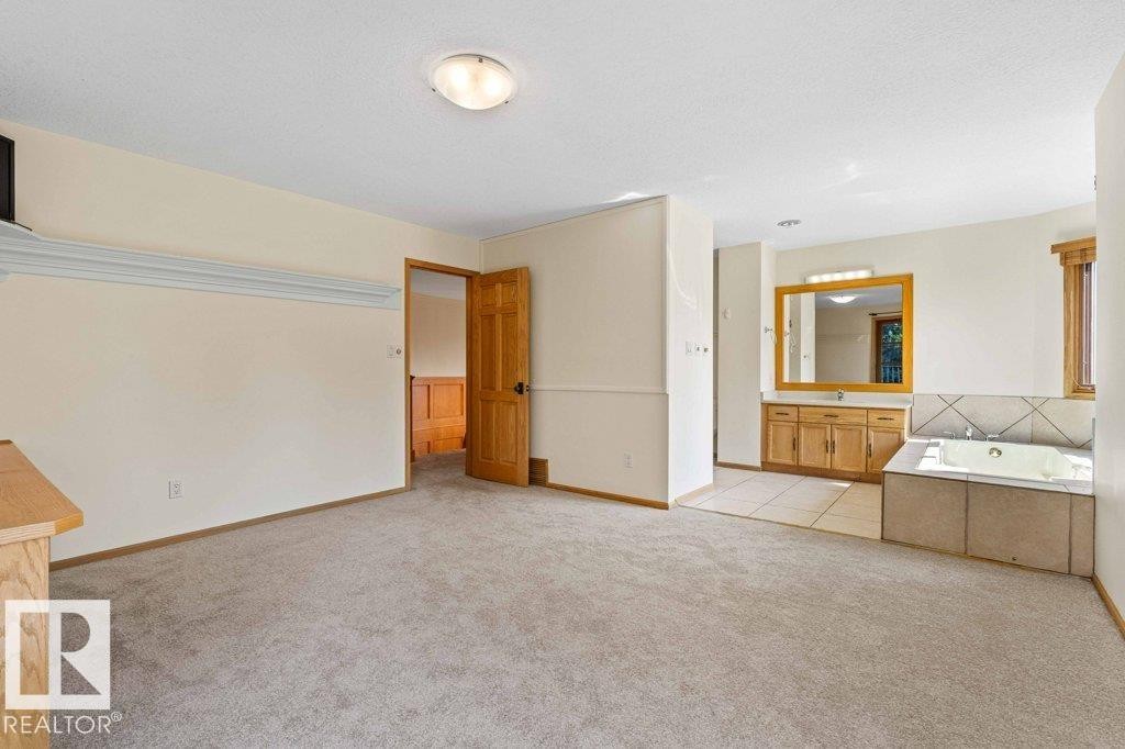 bedroom with new carpet flooring and ensuite with jet tub and shower - 738 Wheeler Road, Edmonton, AB