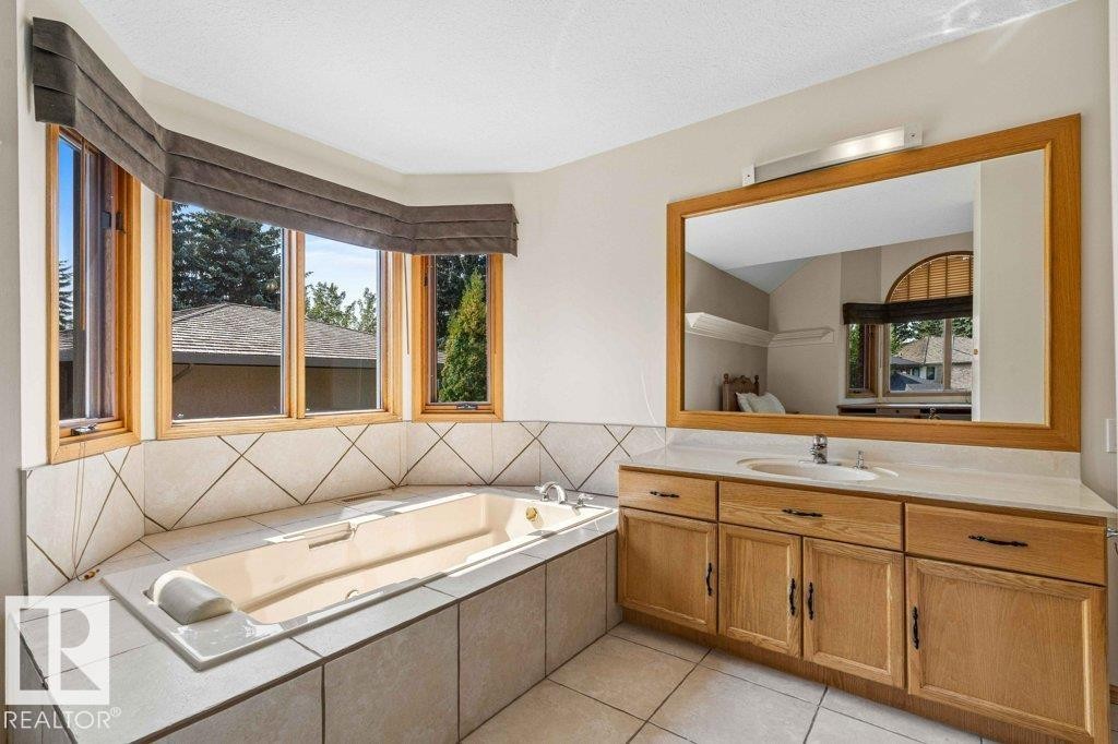 Bedroom featuring full bath featuring a bath, vanity, light tile patterned floors, and a textured ceiling - 738 Wheeler Road, Edmonton, AB