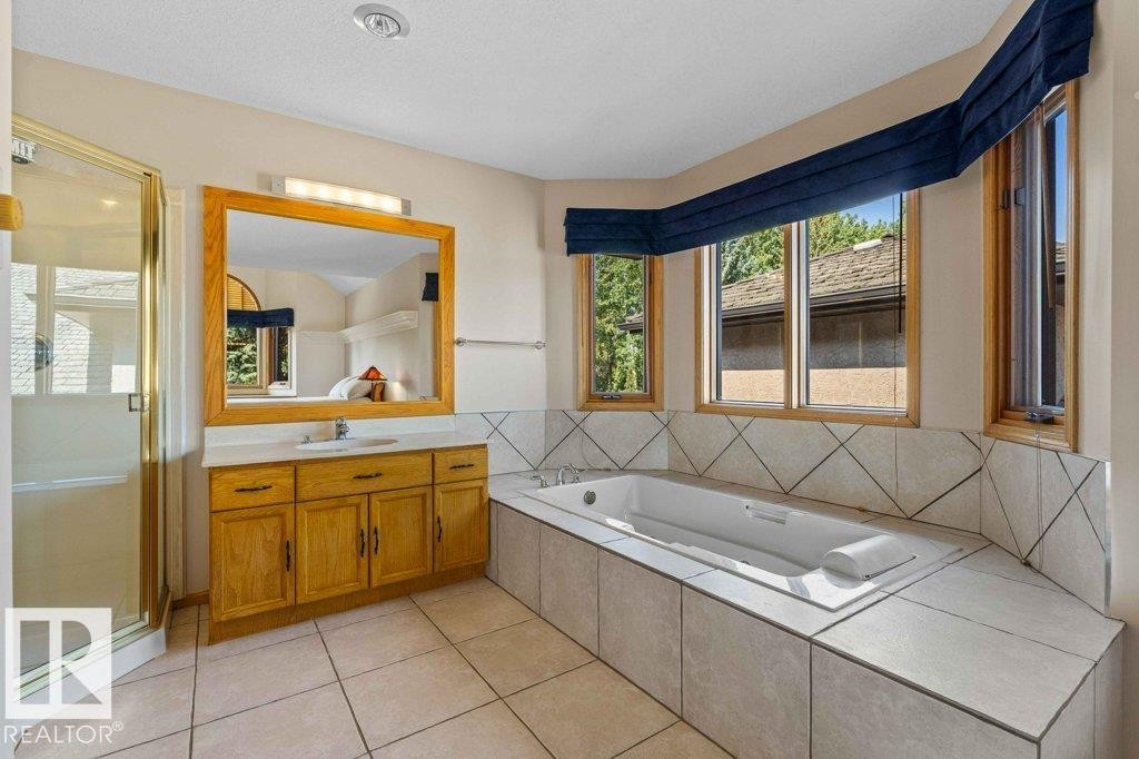 Full bath with vanity, a bath, a shower stall, and light tile patterned floors - 738 Wheeler Road, Edmonton, AB