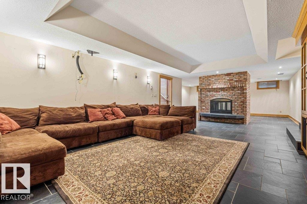 Home theatre w/power 120” screen, featuring two sided wood burning fireplace, heated slate flooring and custom millwork. - 738 Wheeler Road, Edmonton, AB