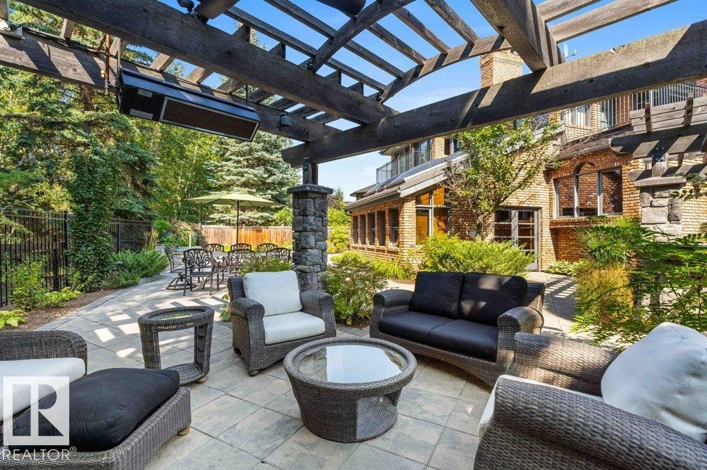 Outdoor living with pergola with two gas radiant heaters, gas light fireplace, patio stone flooring and pizza oven. - 738 Wheeler Road, Edmonton, AB