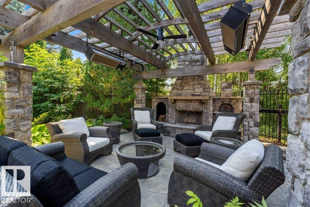 Outdoor living with pergola with two gas radiant heaters, gas light fireplace, patio stone flooring and pizza oven. - 738 Wheeler Road, Edmonton, AB