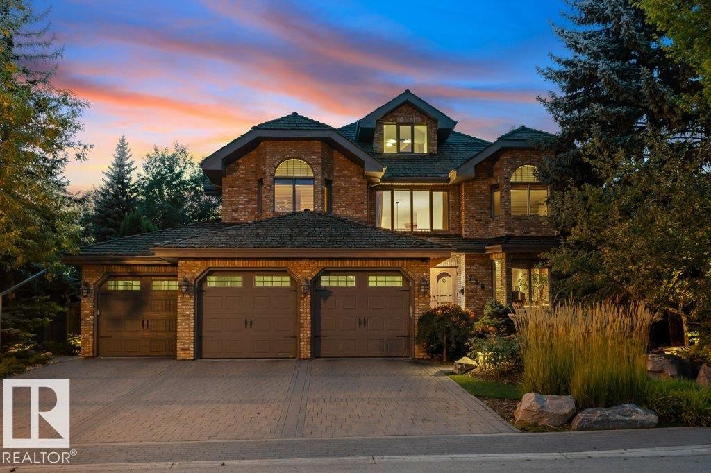 Front of property featuring paving stone driveway, 3 car garage and reclaimed brick exterior. - 738 Wheeler Road, Edmonton, AB