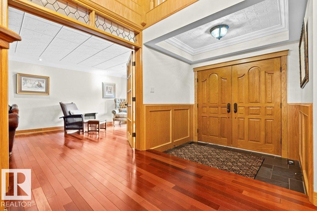 Entrance foyer featuring solid Oak doors and wainscoting, slate tile entrance and Brazilian Cherry hardwood flooring. - 738 Wheeler Road, Edmonton, AB